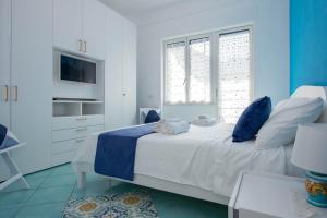 een blauwe en witte slaapkamer met een bed en een raam bij Casa Sammarco in Minori