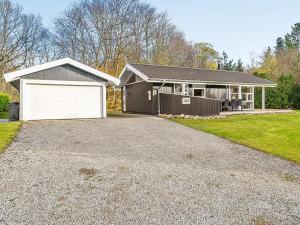a house with a white garage and a driveway at 6 person holiday home in Silkeborg in Silkeborg