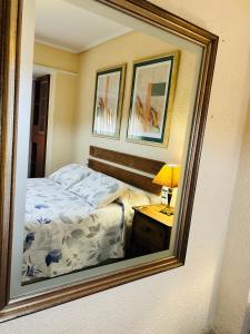 a mirror reflection of a bed in a bedroom at Como en Casa in Valencia