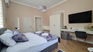 a bedroom with a bed and a flat screen tv at Urban Haven in Subotica