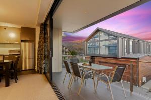 - une cuisine et une salle à manger avec une table et des chaises dans l'établissement Stunning 2 Bedroom Apartment with Balcony!, à Queenstown
