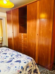 1 dormitorio con armario de madera y cama en Como en Casa, en Valencia