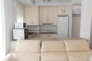 a kitchen with white cabinets and a couch at Mirador del Sol en Torrenueva in Torrenueva
