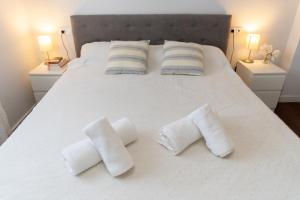 a white bed with three rolled towels on it at Mirador del Sol en Torrenueva in Torrenueva +14 photos