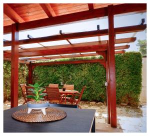 a patio with a wooden pergola and a table with a plant at Thalassa Bari in Bari