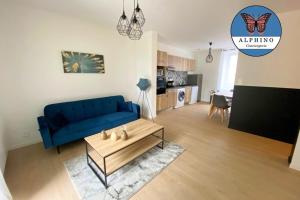 ein Wohnzimmer mit einem blauen Sofa und einem Couchtisch in der Unterkunft Le Monet, spacieux avec terrasse privée in Limoges