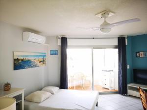 a bedroom with a bed and a tv and a window at Appartement Les Pieds Dans l'eau avec climatisation ! in La Seyne-sur-Mer