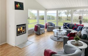 a living room with a couch and a fireplace at Nice Home In Rockneby With Wifi And 3 Bedrooms in Rockneby