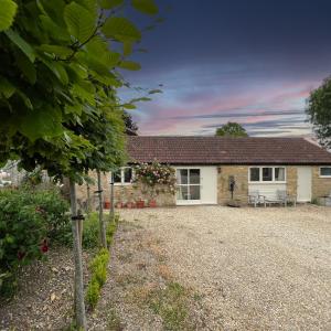 a cottage with a gravel driveway in front of it at Whitley Coach House in Whitley