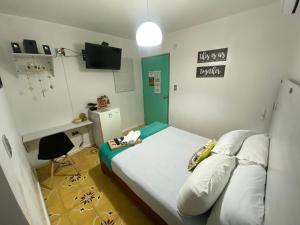 a small room with a bed and a desk at Hotel Nogales Riohacha in Ríohacha