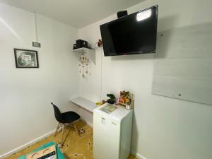 a room with a small refrigerator and a tv on the wall at Hotel Nogales Riohacha in Ríohacha