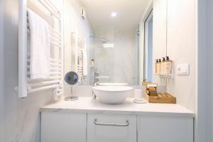 La salle de bains blanche est pourvue d'un lavabo et d'un miroir. dans l'établissement T'Luz, à Porto