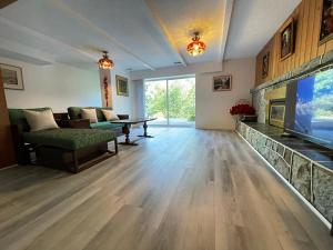 ein Wohnzimmer mit einem TV, einem Sofa und einem Kamin in der Unterkunft The Rhodo Place in Coquitlam
