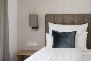 1 dormitorio con 1 cama con almohada negra en Residence Sonja - Apartment Pinus, en Rablà