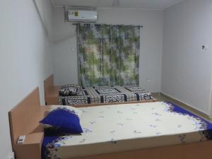 um pequeno quarto com uma cama e uma janela em Jiso Family Apartment em Tamale