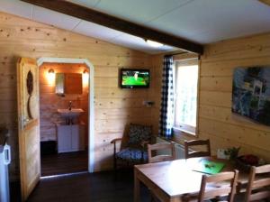 una sala da pranzo con un tavolo e una TV a parete di B&B Hofstede De Groote Laar a Spankeren