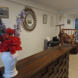 a counter with a vase with flowers on it at Catari's House in Machu Picchu