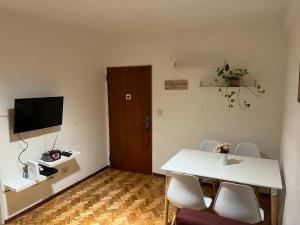 Habitación con mesa, sillas y TV. en Confortable Departamento en Palermo Soho en Buenos Aires