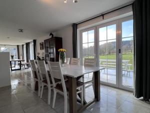 a dining room with a white table and chairs at Bra de Pierre in Lierneux