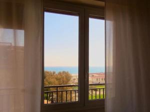 a window in a room with a view of the ocean at Casa Cocò - Appartamento al mare in Lido di Ostia
