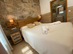 a bedroom with two beds and a stone wall at Las Terrazas de Chilla in Candeleda