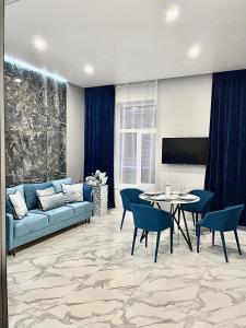 ein Wohnzimmer mit einem blauen Sofa und einem Tisch in der Unterkunft Family Residence Boutique Apartments in Lwiw