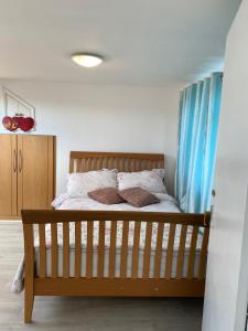 a bedroom with a wooden bed with blue curtains at Comfortable Room in Upper Norwood