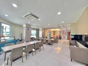 uma sala de jantar com uma mesa longa e cadeiras em Mei Hotel em Taichung