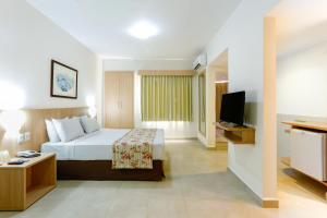 pokój hotelowy z łóżkiem i telewizorem w obiekcie Hotsprings Suite Hotel w mieście Caldas Novas
