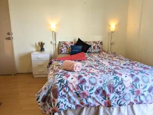 um quarto com uma cama grande e uma colcha floral em Studio 22 Wright Lodge em Adelaide