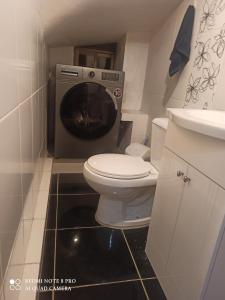 a bathroom with a toilet and a washing machine at DEPARTAMENTO JOSE MARIA in Achumani