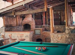 a pool table in a room with a fireplace at Casa de Campo Vizinha da Lua in Monte Verde