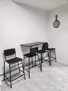 a black table and chairs in a room with a clock at All-ways Home in Burnaby