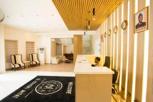 伊巴丹DE MANCHY HOTELS & SUITES的大厅,有人坐在柜台上