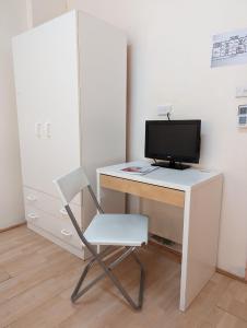 a desk with a computer monitor and a chair at Studio 24 Wright Lodge in Adelaide