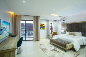 伊巴丹DE MANCHY HOTELS & SUITES的一间带大床和电视的卧室