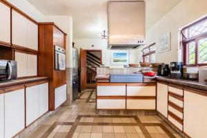 uma cozinha com armários brancos e piso em azulejo em Suítes encantadoras em São Paulo