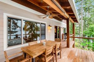 una mesa de madera en un porche con ventilador de techo en Woodstone Cabin, en Hoodsport