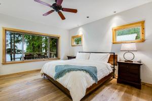 Un dormitorio con una cama y un ventilador de techo. en Woodstone Cabin, en Hoodsport