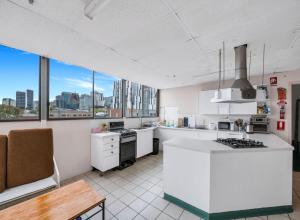een keuken met witte apparatuur en uitzicht op de stad bij Studio 28 Wright Lodge in Adelaide