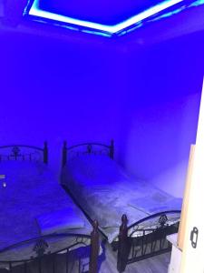 two beds in a dark room with blue lights at Koms Guest House in Gyumri