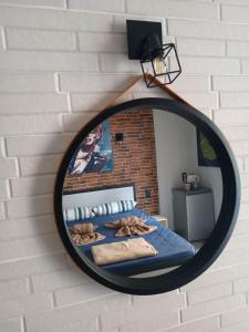 a mirror hanging on a brick wall with a bed at Grecos STAY SKIATHOS in Skiathos Town