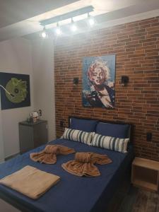 a bedroom with a blue bed with a brick wall at Grecos STAY SKIATHOS in Skiathos Town