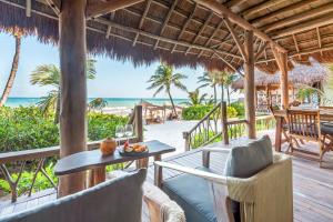 a resort patio with a table and chairs and the beach at Ahau Tulum - Beachfront Hotel in Tulum
