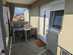 a balcony with a table and chairs and a window at Apartment LIPA in Vir