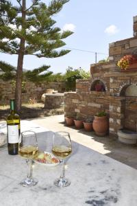 dwa kieliszki białego wina siedzące na stole w obiekcie Tranquil Apartments w mieście Naksos