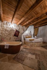 uma casa de banho com banheira e uma cama em hotels crazy horse em Ortahisar