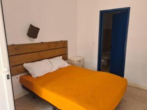 ein Schlafzimmer mit einem großen orangenen Bett und einer blauen Tür in der Unterkunft MONTE DOS FALEIROS in Ermidas