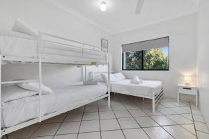 a bedroom with two bunk beds and a window at Rooftop Island Sunsets in Bongaree
