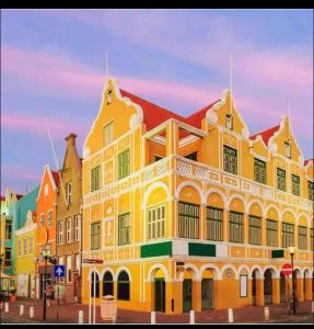 a large yellow building with a red roof at City Views Spacious Mezzanine Apartments in Willemstad